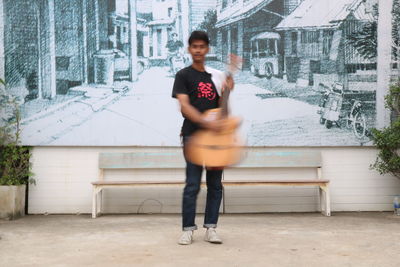 Full length of woman standing against building in city