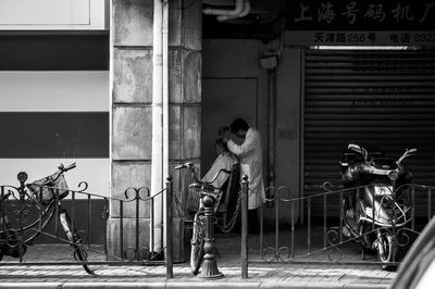 People in shopping cart against building