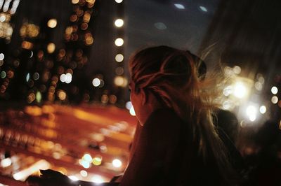 Portrait of woman with illuminated lights at night