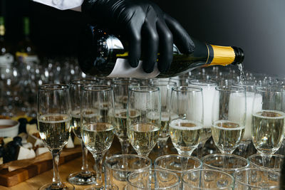 Waiter pours champagne into glasses, close-up of the hands. party drinks. luxury raw of alcohol.