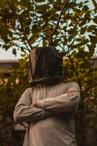 Rear view of woman standing by tree