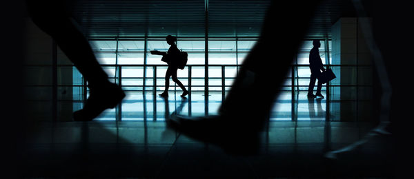 Silhouette people walking in corridor of building