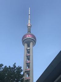 Low angle view of communications tower against sky