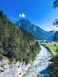 Scenic view of landscape and mountains against blue sky