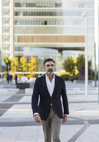 Businessman walking in front of office building