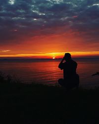 Silhouette man on beach against sky during sunset