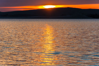 Scenic view of lake against romantic sky at sunset