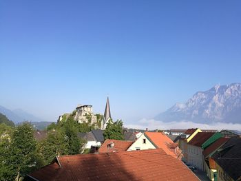 Houses in town against clear blue sky