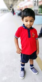 Full length of innocent boy standing at railroad station platform