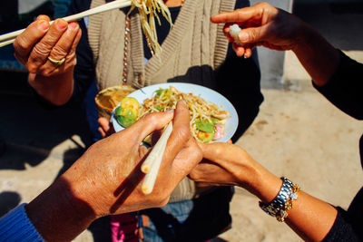 Cropped hands of people eating food