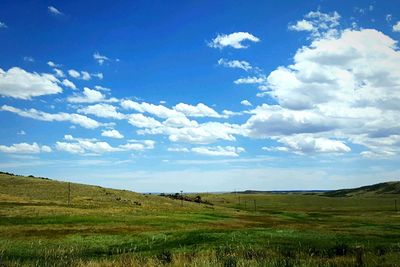 Scenic view of grassy field against cloudy sky