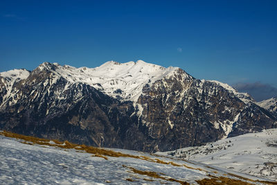 Scenic view of snowcapped mountains against clear blue sky
