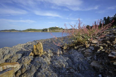 Rocks by sea against sky