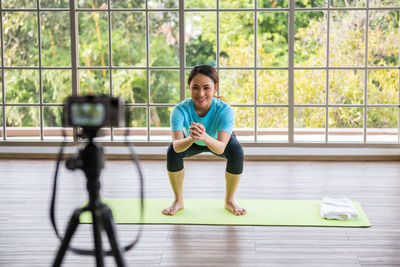 Online asian coach squat exercise live record by mirror-less camera