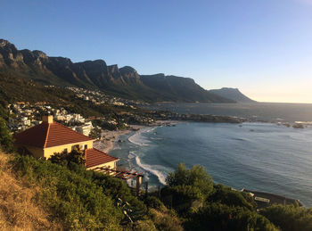 High angle view of sea and buildings against clear sky