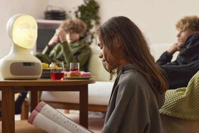 Girl doing homework with robotic voice assistant