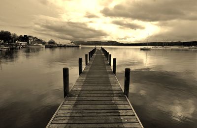 Boardwalk over lake against sky