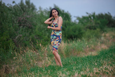 Full length portrait of beautiful young woman on land