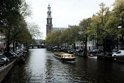 Canal amidst buildings in city against sky