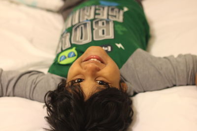 Close-up of young woman lying on bed at home