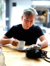 Man holding coffee cup on table