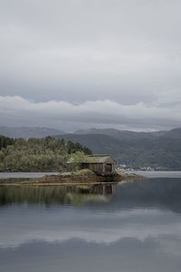 Scenic view of lake by trees against sky