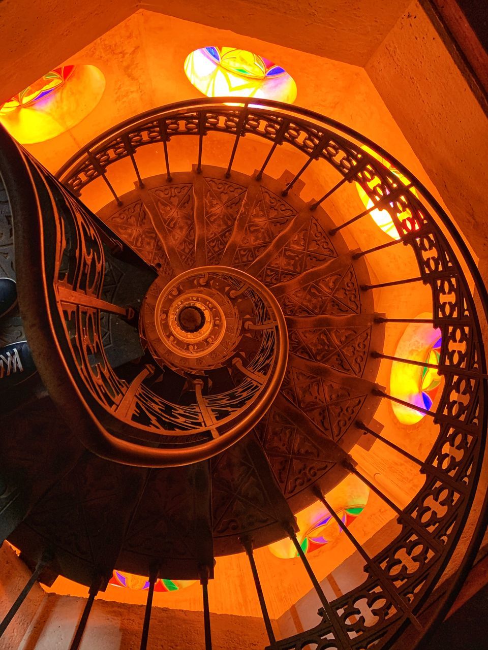 LOW ANGLE VIEW OF ILLUMINATED SPIRAL STAIRCASE