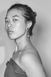 Close-up portrait of young woman against white background