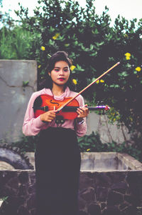 Young woman standing against wall