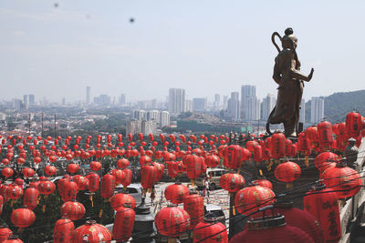 Statue of people in city against sky