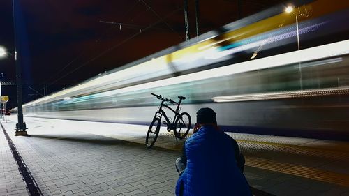 Man talking on smart phone while sitting at railroad station platform