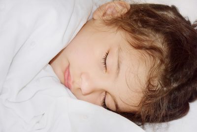 Close-up of girl sleeping on bed