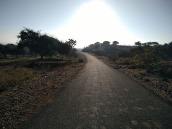 Road amidst trees against clear sky