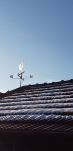 Low angle view of weather vane against clear sky