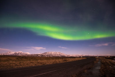 Road amidst landscape against dramatic sky at night