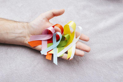 Close-up of hand holding multi colored paper