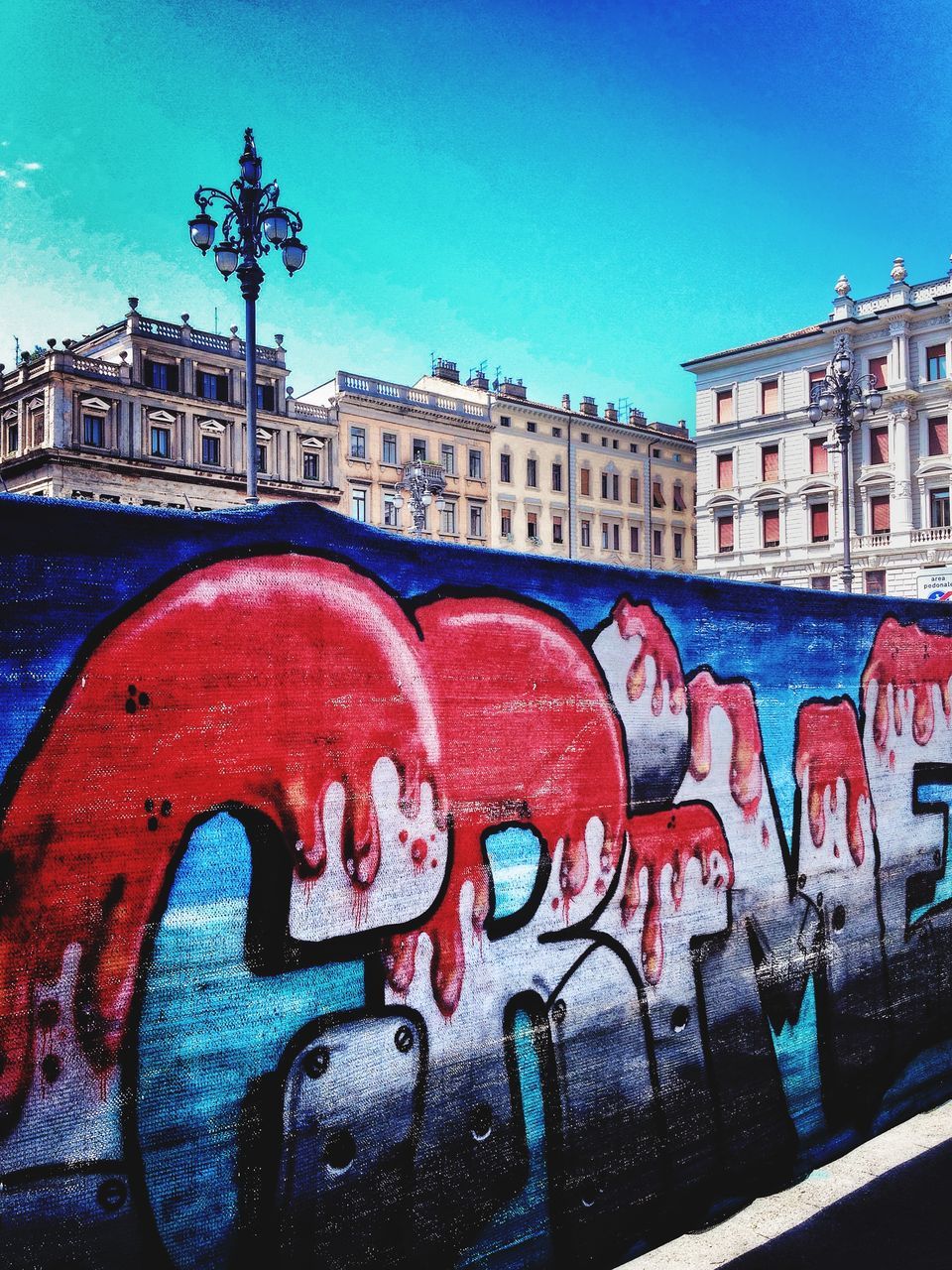 building exterior, architecture, built structure, text, western script, communication, graffiti, clear sky, blue, city, art, red, outdoors, creativity, wall - building feature, water, art and craft, day, sign, sky