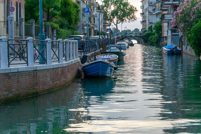 Boats moored on canal in city