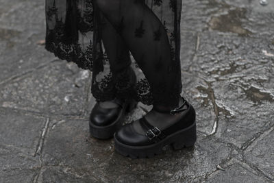 Low section of woman standing on street