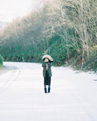 Full length of woman standing in rain