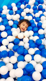 High angle view portrait of smiling boy in ball pool