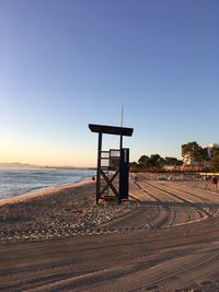 Lifeguard hut on beach against clear sky