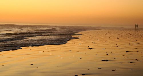 Scenic view of beach against sky during sunset