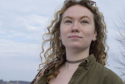 Close-up of young woman against sky