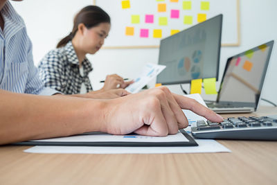 Midsection of woman using laptop on table