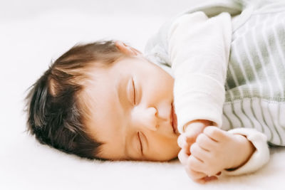 Close-up of baby sleeping on bed