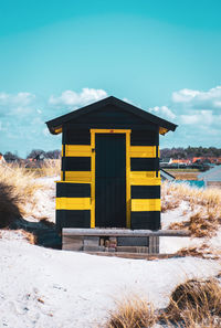Wooden hut at skanör beach against clear blue sky.