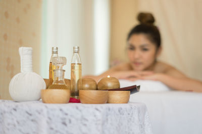 Massage oil in bottles by bowls on table in spa