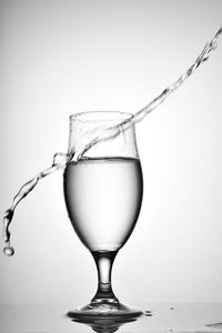 Close-up of wineglass on table against white background