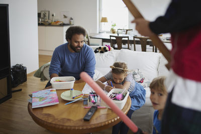 Father playing with children at home